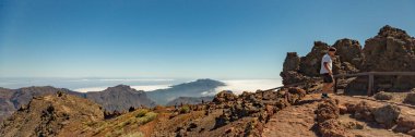 Ulusal Park Caldera de Taburiente 'nin hava manzarası, Roque de los Muchachos' un dağ zirvesinden görülen volkanik krater. El Hierro bulutların üzerinde ufukta. La Palma, İspanya