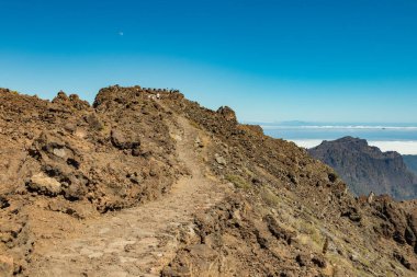 Ulusal Park Caldera de Taburiente 'nin hava manzarası, Roque de los Muchachos' un dağ zirvesinden görülen volkanik krater. El Hierro bulutların üzerinde ufukta. La Palma, İspanya