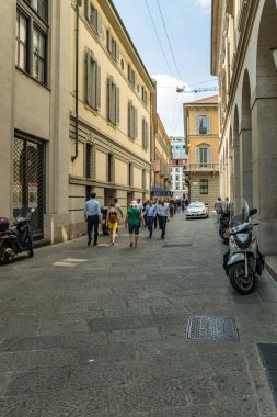 MILAN, İtalya - 01 Ağustos 2019: Milano 'nun merkezinde turistler ve yerliler yürüyor. Dükkanlar, butikler, kafeler ve restoranlar.