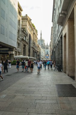 MILAN, İtalya - 01 Ağustos 2019: Milano 'nun merkezinde turistler ve yerliler yürüyor. Dükkanlar, butikler, kafeler ve restoranlar.