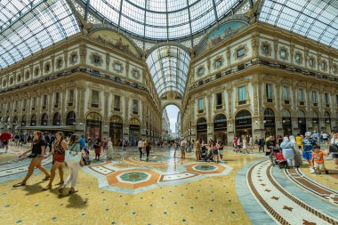 MİLAN, İtalya - 1 AĞUSTOS 2019: Milano 'da güzel bir yaz gününde ünlü Galleria Vittorio Emanuele II. Dükkanlar, butikler, kafeler arasında turistler ve yerliler yürüyor.