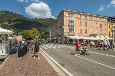 Como, ITALY - 4 Ağustos 2019: Güzel İtalyan Como şehrinin merkezinde sakin bir caddede yerel halk ve turistler. Çok popüler bir tatil merkezinde, güneşli bir yaz günü..