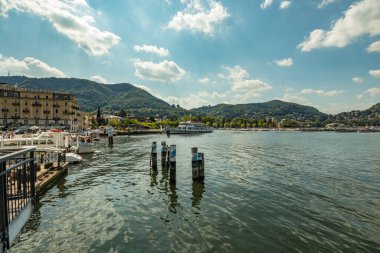 Como, ITALY - 4 Ağustos 2019: Güzel İtalyan Como şehrinin göl kenarındaki gezinti alanında yerel halk ve turistler. Çok popüler bir tatil merkezinde, güneşli bir yaz günü.