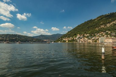 Como, ITALY - 4 Ağustos 2019: Como Gölü yakınlarındaki yeşil ormanlık dağlarda daireler, villalar, oteller. Güzel İtalyan Como şehri. Çok popüler bir tatil merkezinde, güneşli bir yaz günü..