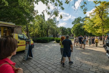 Como, ITALY - 4 Ağustos 2019: Güzel İtalyan Como şehrinin göl kenarındaki gezinti alanında yerel halk ve turistler. Çok popüler bir tatil merkezinde, güneşli bir yaz günü.
