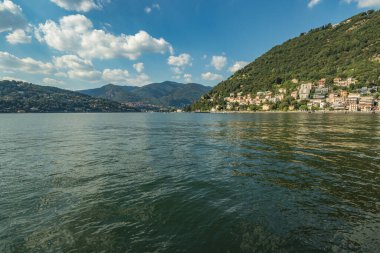 Como, ITALY - 4 Ağustos 2019: Como Gölü yakınlarındaki yeşil ormanlık dağlarda daireler, villalar, oteller. Güzel İtalyan Como şehri. Çok popüler bir tatil merkezinde, güneşli bir yaz günü..