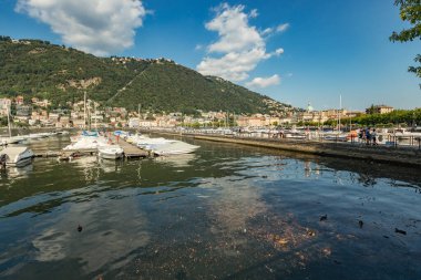 Como, ITALY - 4 Ağustos 2019: Güzel İtalyan Como şehrinin göl kenarındaki gezinti alanında yerel halk ve turistler. Çok popüler bir tatil merkezinde, güneşli bir yaz günü.