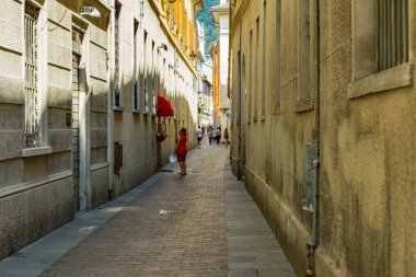 Como, ITALY - 4 Ağustos 2019: Güzel İtalyan Como şehrinin merkezinde sakin bir caddede yerel halk ve turistler. Çok popüler bir tatil merkezinde, güneşli bir yaz günü..