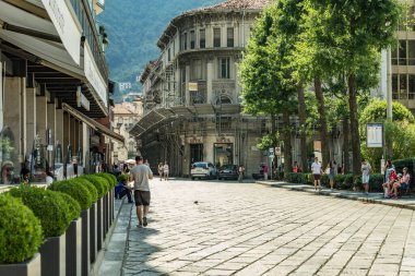 Como, ITALY - 4 Ağustos 2019: Güzel İtalyan Como şehrinin merkezinde sakin bir caddede yerel halk ve turistler. Çok popüler bir tatil merkezinde, güneşli bir yaz günü..