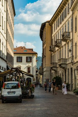 Como, ITALY - 4 Ağustos 2019: Güzel İtalyan Como şehrinin merkezinde sakin bir caddede yerel halk ve turistler. Çok popüler bir tatil merkezinde, güneşli bir yaz günü..