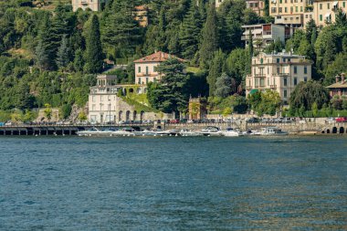 Como, ITALY - 4 Ağustos 2019: Como Gölü yakınlarındaki yeşil ormanlık dağlarda daireler, villalar, oteller. Güzel İtalyan Como şehri. Çok popüler bir tatil merkezinde, güneşli bir yaz günü..