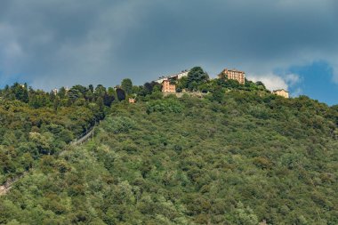 Como, ITALY - 4 Ağustos 2019: Como Gölü yakınlarındaki yeşil ormanlık dağlarda daireler, villalar, oteller. Güzel İtalyan Como şehri. Çok popüler bir tatil merkezinde, güneşli bir yaz günü..