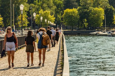 Como, ITALY - 4 Ağustos 2019: Güzel İtalyan Como şehrinin göl kenarındaki gezinti alanında yerel halk ve turistler. Çok popüler bir tatil merkezinde, güneşli bir yaz günü.