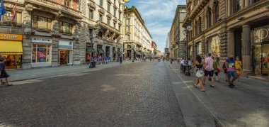 MILAN, İtalya - 01 Ağustos 2019: Milano 'nun merkezinde turistler ve yerliler yürüyor. Dükkanlar, butikler, kafeler ve restoranlar. Süper geniş açı panoraması.