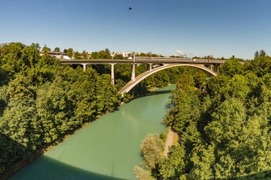 Bern, İsviçre - 30 Temmuz 2019: Nehir üzerindeki demiryolu köprüsü. İsviçre 'nin başkenti Aare nehri üzerindeki köprüden geçen tren..
