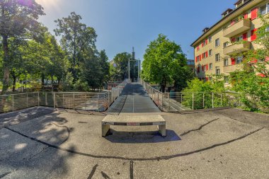 Bern, Switzerland - July 30, 2019: A wide metal mounted pedestrian bridge in the Lorrainestrasse street of the capital. Panoramic. View at sunny summer day.