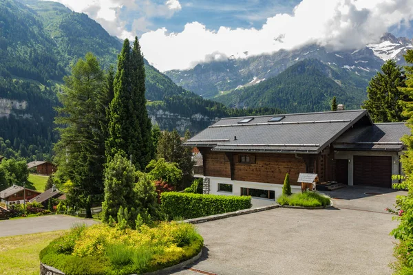 İsviçre 'nin küçük Champery tatil köyünden İsviçre Alpleri' nin karlı dağ zirvelerinin muhteşem manzarası. Parlak mavi gökyüzü ve kayalık tepelerin üzerinde beyaz kabarık bulutlar. Yol boyunca kadehler.