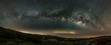 Gözlemevi yakınlarındaki Teide Ulusal Parkı 'nın üstündeki ilkbahar gökyüzünde Samanyolu. Jüpiter yıldız kümeleri ve nebulalar tarafından kuşatılmıştır. Sahilde gece lambaları ve arka planda Büyük Kanarya.