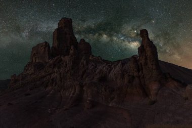 İlkbahar gökyüzünde Samanyolu kırmızı dar volkanik kayaların üzerinde Gözlemevi yakınlarındaki Teide Ulusal Parkı. Jüpiter yıldız kümeleri ve nebulalar tarafından kuşatılmıştır. Gece gökyüzündeki Brihgt yıldızları.