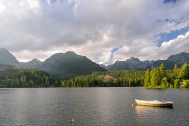 Dağ otelin yanında bir göl ile tekne ile huzurlu dağ sahne. Doğal görünümünü Strbske Pleso, yüksek Tatras Milli Parkı, Slovakya.