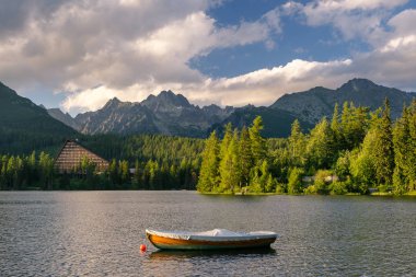 Dağ otelin yanında bir göl ile tekne ile huzurlu dağ sahne. Doğal görünümünü Strbske Pleso, yüksek Tatras Milli Parkı, Slovakya.