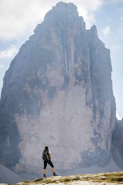 Young woman tourist enjoying view of famous rock formation Tre Cime. — Stock Photo, Image