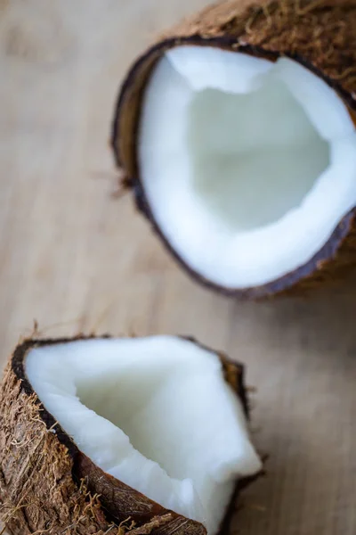 Cracked coconut on rustic wooden table.