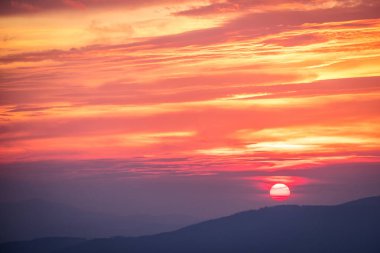 Dağlarda gün batımı güneşli ışınlar ile birlikte. Dramatik sahne.