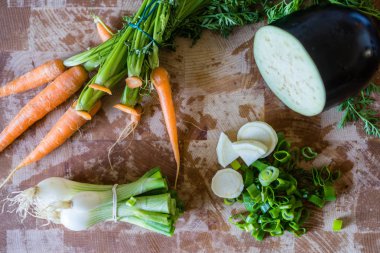 Çeşitli organik sebze maddeler düzenlenen ve bir sebze çorbası için hazır. Healhy bitkisel bir ahşap kesme tahtası üzerinde. Üstten Görünüm.