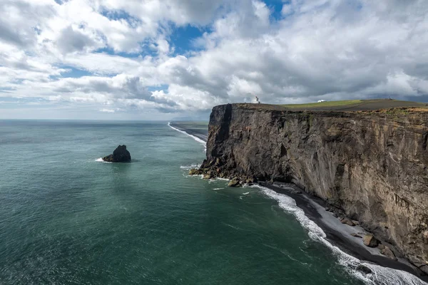 Paesaggio costiero islandese con faro su una scogliera . — Foto Stock