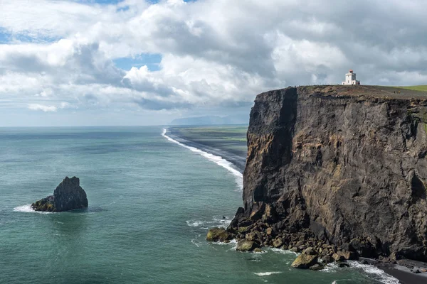 Paisagem costeira islandesa com farol em um penhasco . — Fotografia de Stock