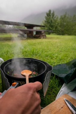 Şiddetli bir yağmur bir çadırda iz gıda hazırlama. İskandinavya'seyahat.