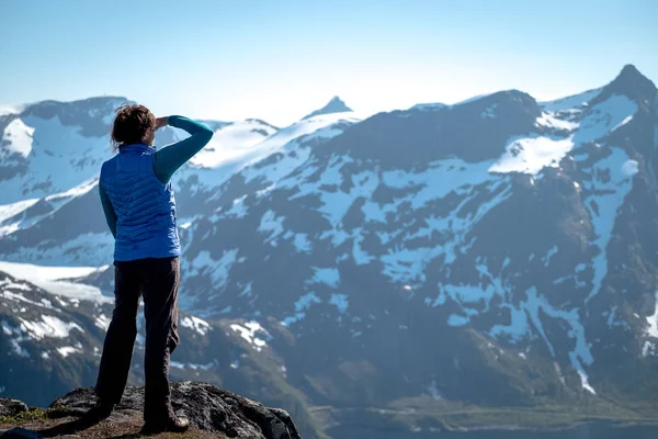 Unga kvinnliga hiker beundrar vacker utsikt över dramatiska landskap i ett Norge. — Stockfoto