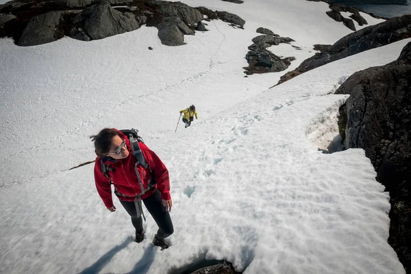 Caminhadas em dificuldade terreno nevado em uma Noruega durante um dia ensolarado de verão . — Fotografia de Stock