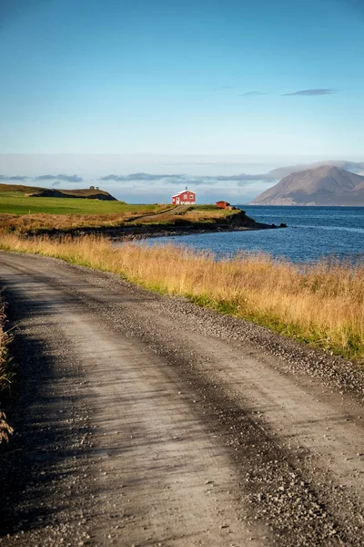 オーシャン ショア アイスランドの人里離れた家につながるほこりっぽい道の垂直方向のビュー — ストック写真