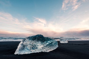 Jokulsarlon buzul lagoon yakınındaki siyah volkanik sahilde buz, İzlanda kış. Güzel bir akşam ışık siyah kum Plajı'nda buz buzul parçası detay.