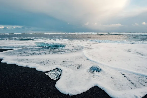氷の手配氷河ラグーン近くの黒い火山ビーチ 冬のアイスランド 美しい夜の光で黒い砂のビーチで氷の氷河のかけらの詳細 — ストック写真