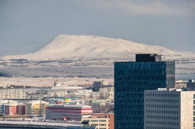 Reykjavik, İzlanda'daki modern geliştirme kar önünde kaplı dağlar ve fiyortları.