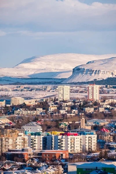 Dikey görünümünde Reykjavik şehir merkezinde bir altın akşam ışığı. Sermaye şehir İzlanda Reykjavik kış karla kaplı dağlarla çevrili.