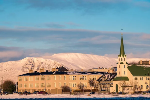 在一个金色的夜晚的灯光下 在市中心与路德教会的美丽拍摄 冰岛首都雷克雅未克冬天四周覆盖着积雪的山脉 — 图库照片