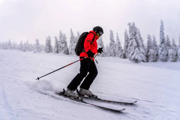 Θηλυκό σκιέρ, ντυμένος με κόκκινο σακάκι στην πίστα σκι. — Φωτογραφία Αρχείου