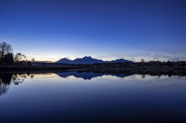 Güzel sonbahar dağ manzarası göl, renkli ağaçlar ve yüksek tepeler Yüksek Tatras, Slovakya ile huzurlu sahne bardak mavi saat.