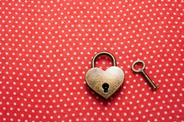 Heart shaped lock and key on red background