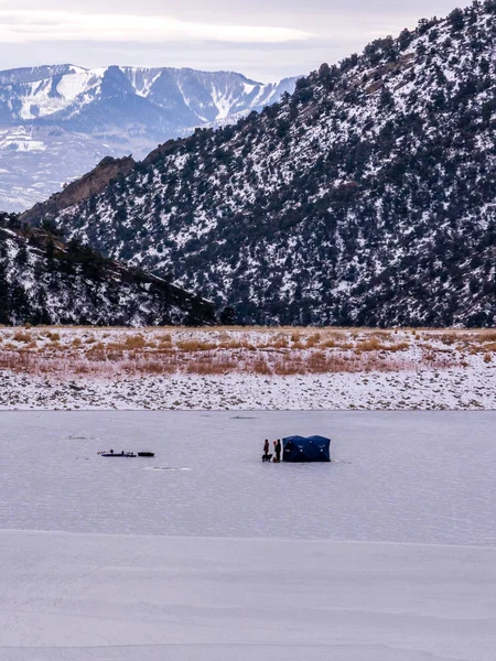 Hombre Ice Fishing on Frozen Lake — Foto de Stock