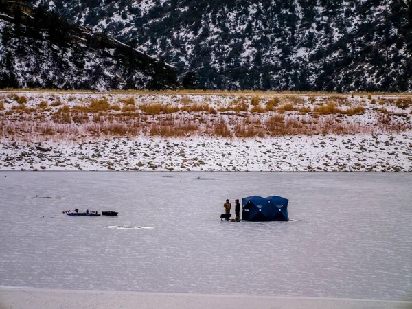 Hombre Ice Fishing on Frozen Lake with Dog — Foto de Stock