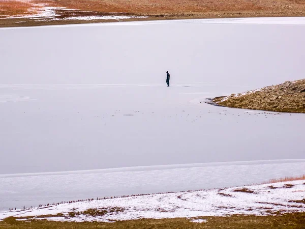 Pescador de hielo solo en el lago congelado en Colorado — Foto de Stock