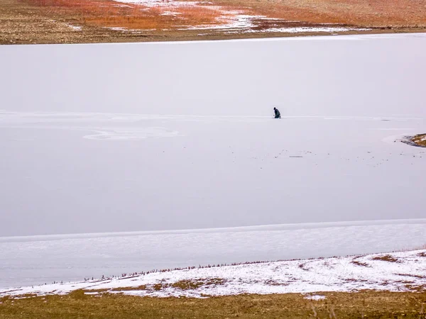Yalnız buz balıkçı buz bir delik hazırlama — Stok fotoğraf