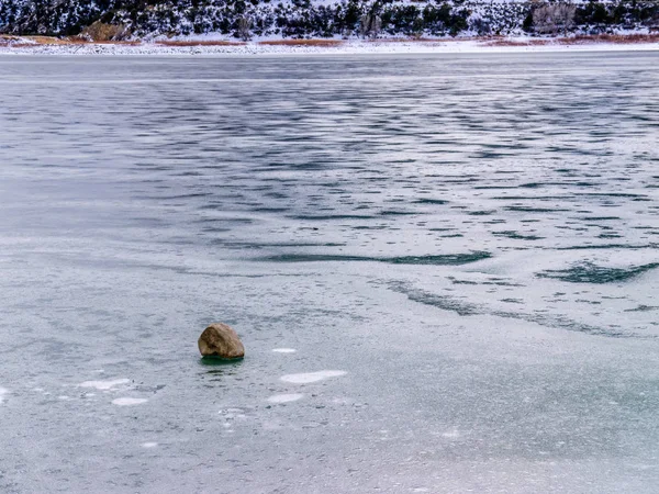 Donmuş gölün yüzeyinde tek Boulder — Stok fotoğraf