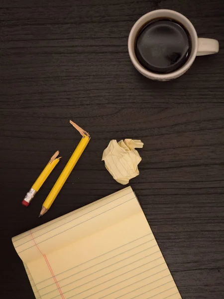 Escritorio, taza de café, lápiz roto, bloc de notas amarillo — Foto de Stock