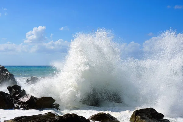 Mořské vlny se silně odrážejí na skály. — Stock fotografie